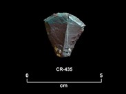 Fragment de pierre taillée rougeâtre et verte avec un front convexe et des bords convergeants à la base. La cote CR-435 et une échelle de 0 à 5 centimètres sont inscrites en dessous.