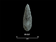 Lance-shaped greenish chipped stone with a convex base. The number CR-217 and a scale of 1 unit:10 cm are shown below.