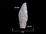 Two altered fragments of a white chipped stone point. The base is shaped in a peduncle. The number CR-580 is attributed to the top and the number CR-617 to the bottom. A scale of 0 to 5 centimetres is inscribed on the bottom.