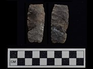 Two sides of a rectangular grey-ochre chipped stone composed of three fragments. The number BiEx-1738 is inscribed on the right-side face. Below the image is a photographic scale with black and white squares.