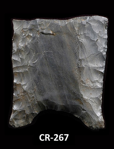 Side of a fragment of grey-green chipped stone. The side is slightly concave with thinned edges and a concave grooved base. The number CR-267 is inscribed on the bottom, and a 0-to-5 centimetre scale is shown below.