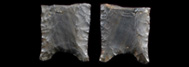 Deux faces d’un fragment de pierre taillée gris-vert. Les deux faces sont légèrement concaves, les bordures sont amincies et la base a une encoche concave.