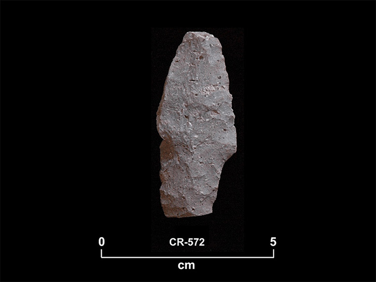 Greenish chipped stone with a peduncle-shaped base. The number CR-572 and a scale of 1 unit:5 cm are shown below.