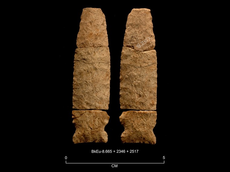 Deux faces d’une pierre taillée ocre de forme lancéolée, cassée en trois morceaux. La base présente des encoches latérales. La cote BkEu-8.665- 2346-2517 est inscrite en dessous. Au bas de l'image, il y a une échelle graphique de 0 à 5 centimètres.  