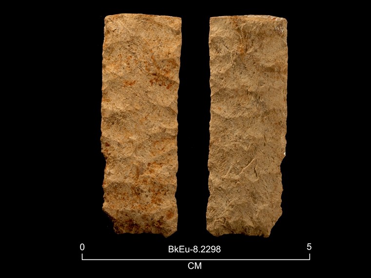 Deux faces d'une pierre taillée rectangulaire de couleur ocre. La cote BkEu-8.2298 est inscrite en dessous. Au bas de l'image, il y a une échelle graphiquede  0 à 5 centimètres.  