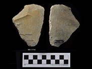 Two sides of a beige chipped stone of irregular polygonal shape. The number BiEx-23.564 is inscribed on the bottom and on the left-side face. Below the image is a photographic scale with black and white squares.